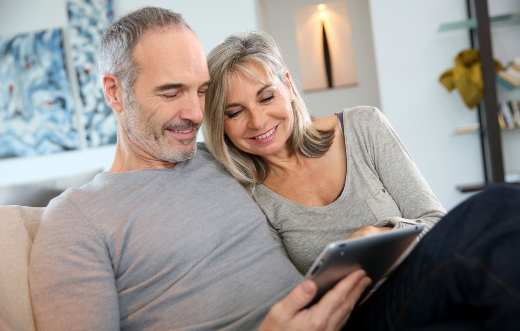 Mature couple at home websurfing with tablet